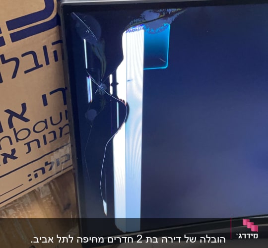 מסך שבור ליד קופסת קרטון עם כיתוב בעברית